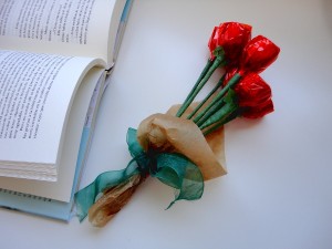 Ramo de rosas rojas junto a un libro abierto