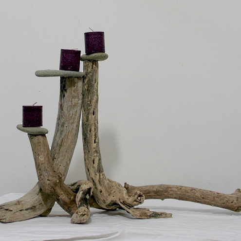 Candelabros para velas con trozos de madera y piedras de playa